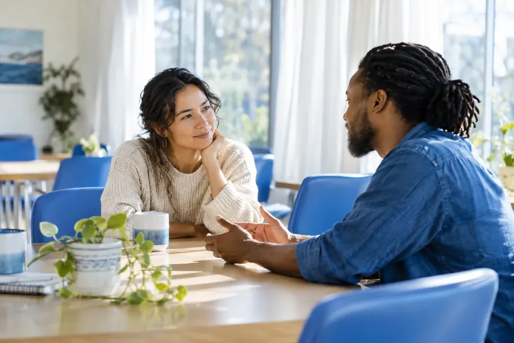 Two people sharing a thoughtful conversation in a bright room.