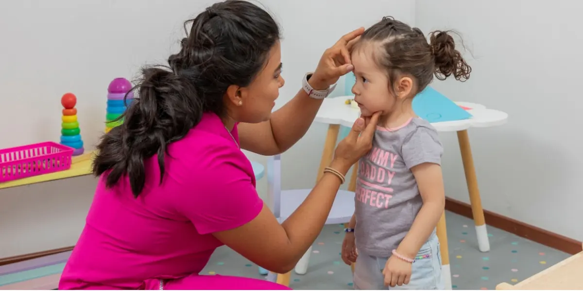 A healthcare professional talks with a young child.