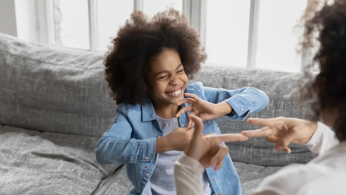 A child and an adult share a playful moment at home.