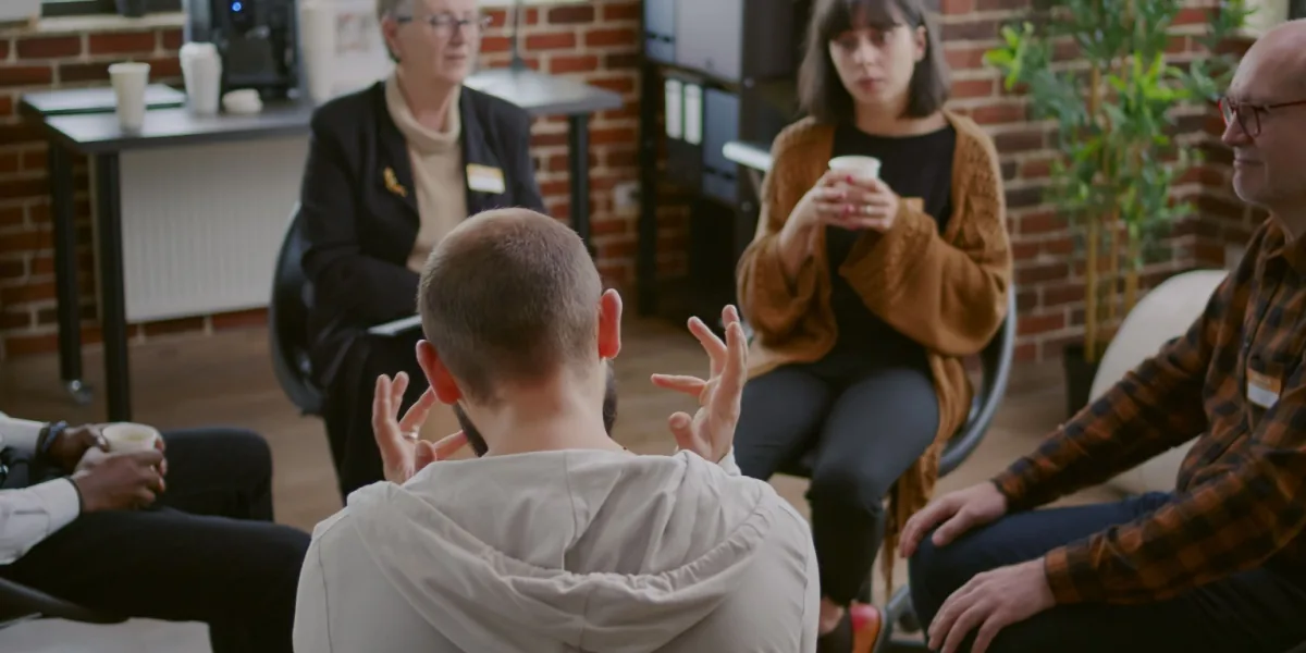 Adults sit in a circle during a group discussion.