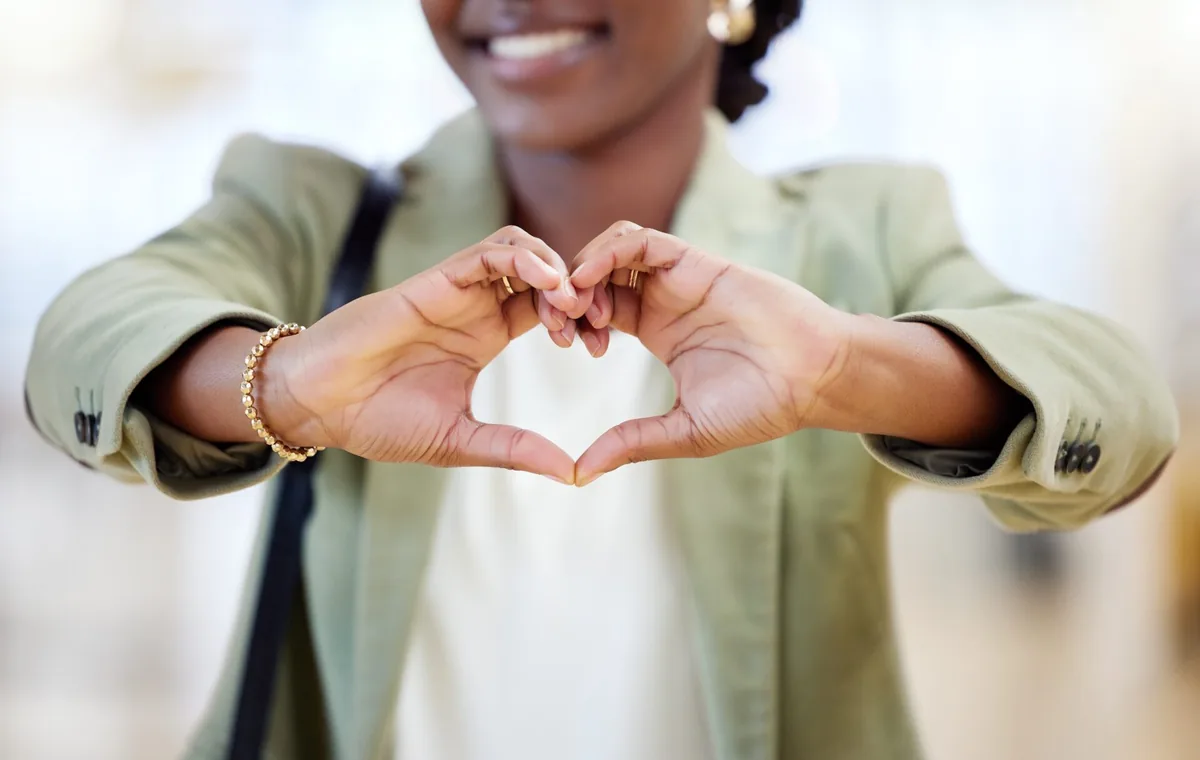 A person forms a heart shape with their hands.