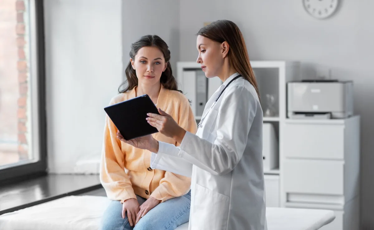 A healthcare professional explains information to a patient in a clinic.