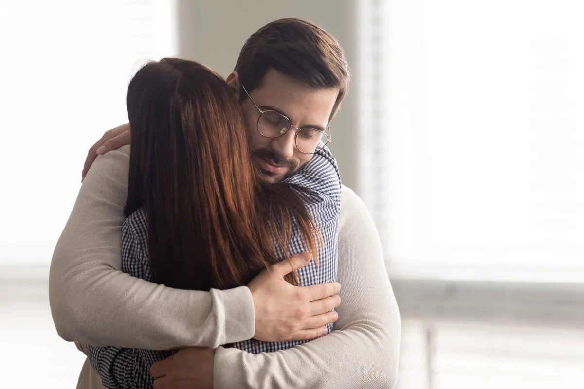 A couple shares a close, comforting embrace.