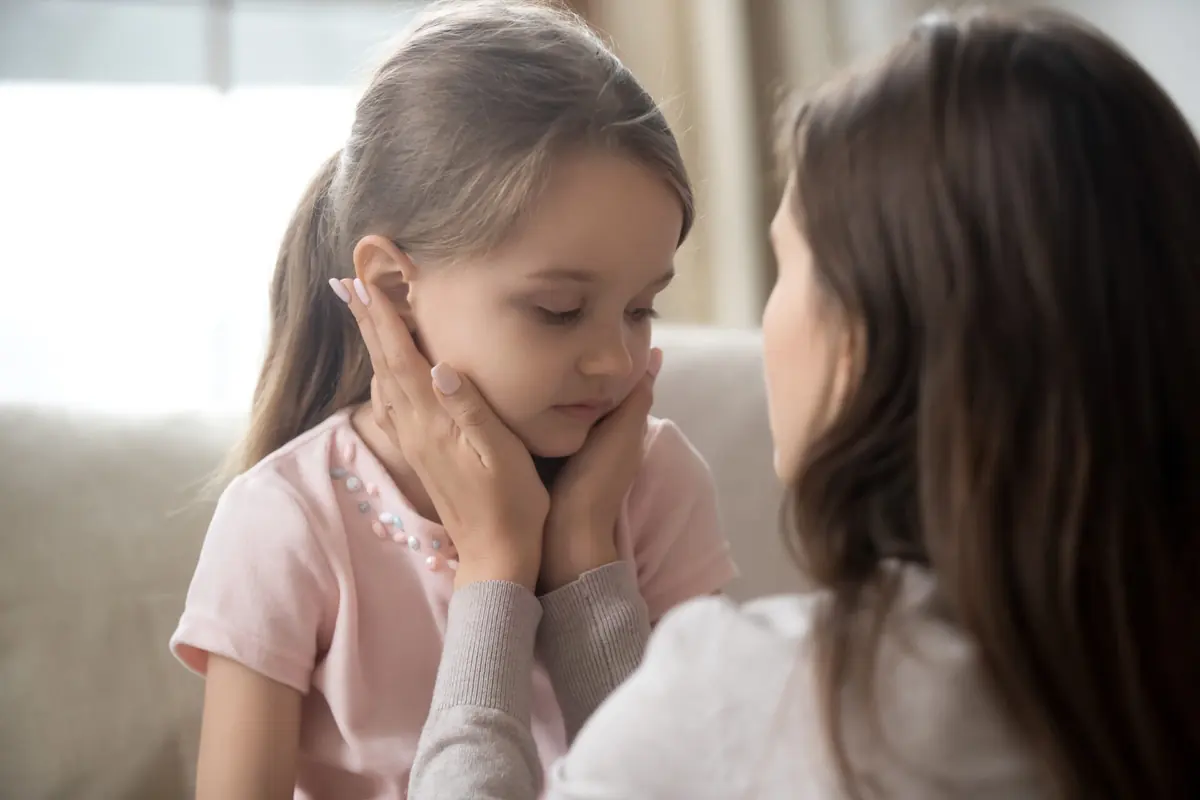 An adult and a young child share a close conversation at home.