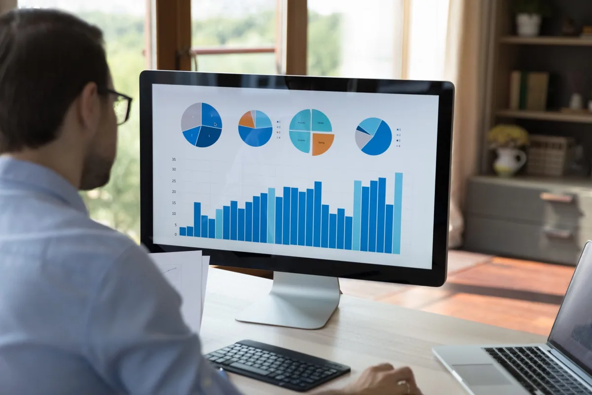 A person reviews charts on a computer monitor.
