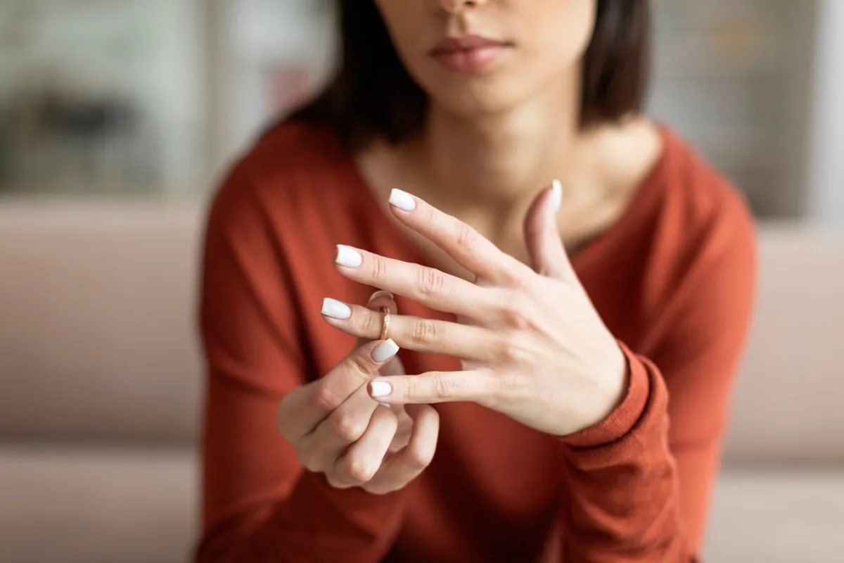 A person holds a ring between their fingers.