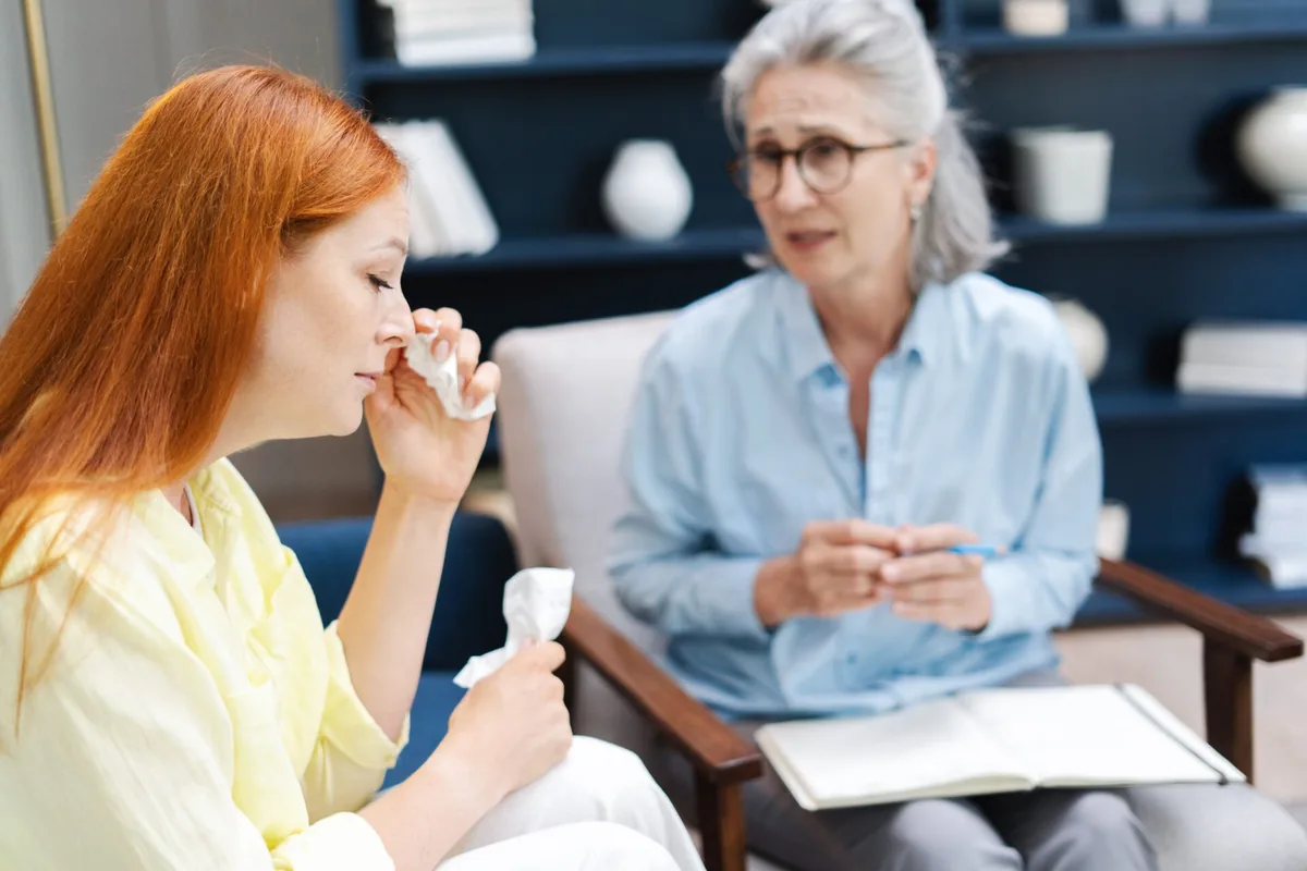A healthcare professional discusses a medicine bottle with a patient.
