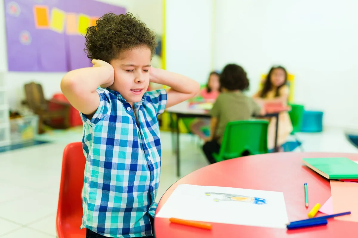 A young child joins a classroom learning activity.