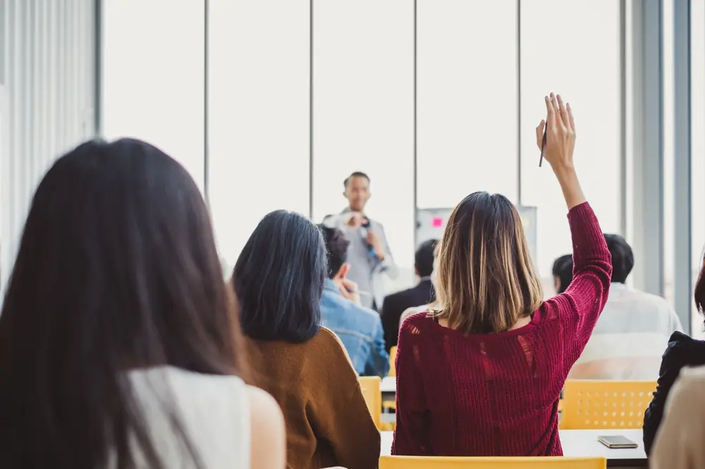 People raise their hands during a group workshop.