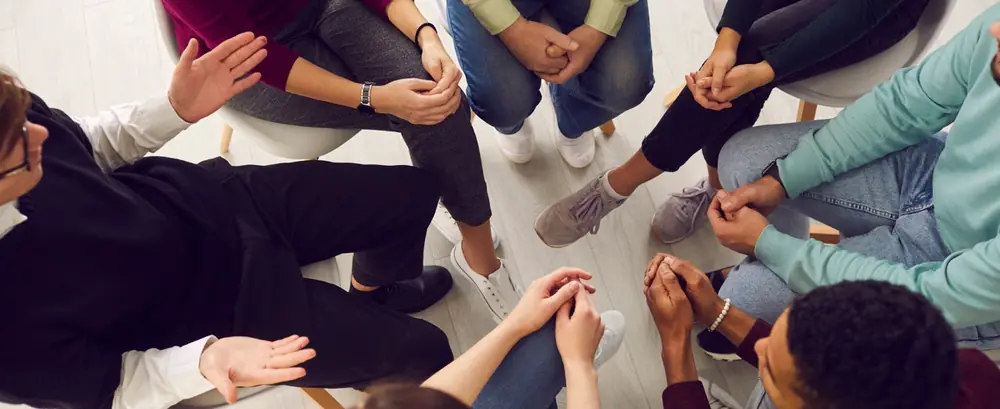 People sit together in a circle during a group discussion.